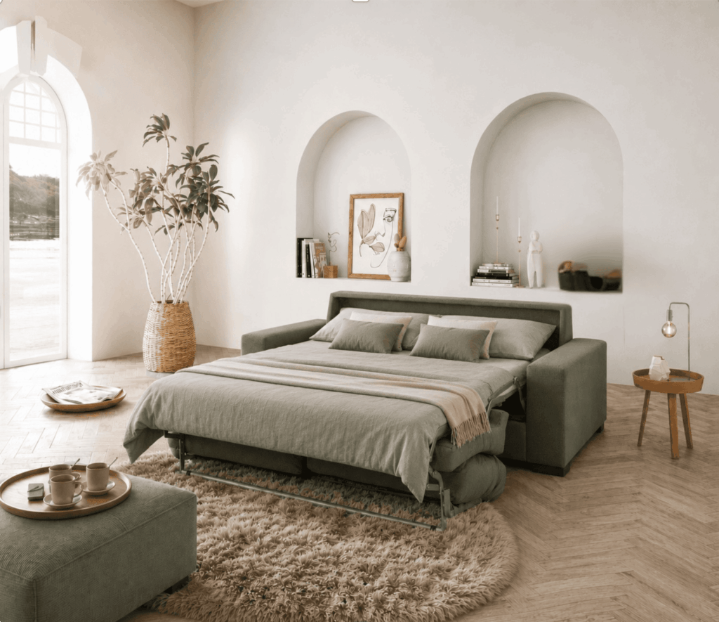 Sofá cama de sistema italiano de apertura en verde oliva, en habitación de apartahotel mediterráneo